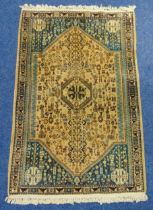 Persian wool carpet light brown ground with repeating motif decoration within a turquoise and