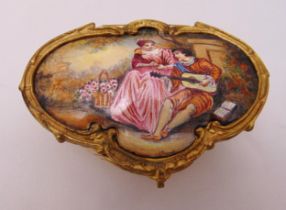 A Viennese enamel box shaped oval with gilt metal mounts on three ball feet, the hinged cover