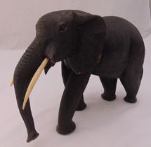 A carved wooden African elephant with bone tusks, 24.5 x 39 cm
