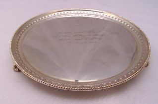 A hallmarked silver presentation salver with bead and husk borders on three ball and claw feet,