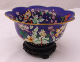 A Chinese cloisonné shaped circular fruit dish decorated with flowers and leaves on a hardwood