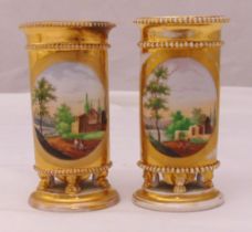 A pair of Staffordshire cylindrical vases hand painted and gilded on claw feet and raised circular