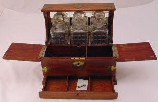 An oak Tantalus with three cut glass decanters with drop stoppers to include key, 31.5 x 35.5 x 25.