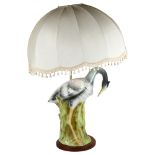 A large Majolica table lamp and shade in the form of a heron amongst the reeds, on a turned wood