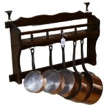 A graduated set of 5 French 1970s copper pans, with wooden hanging rack, diameter of largest pan