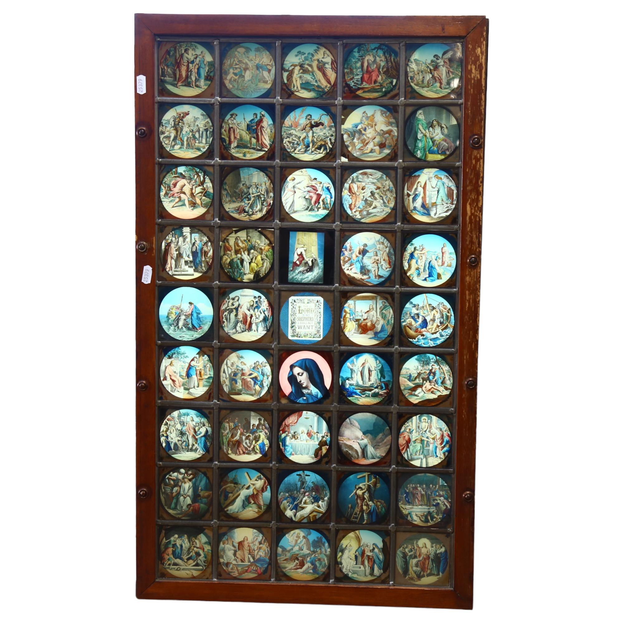 A late 20th century lightbox, the leadlight glass panel depicting 45 religious scenes, the central