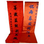 A boxed Oriental red silk scroll with embroidered letters, W43cm, a Chinese silk wall-hanging