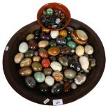 A large quantity of ornamental eggs and various stones, in a hardwood bowl, bowl diameter 49cm.