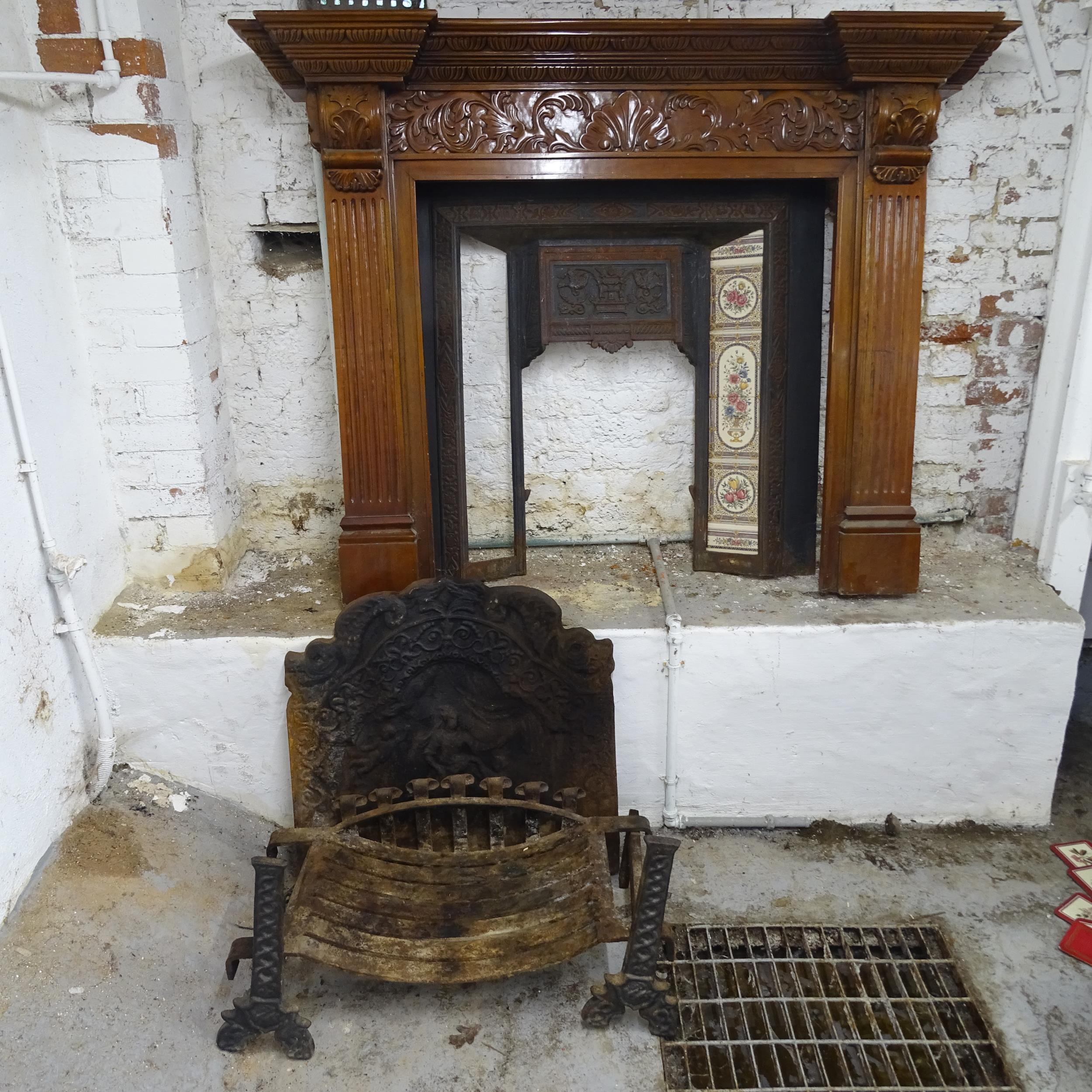 A Victorian fireplace comprising a cast iron fire surround (98x99cm), a carved mahogany