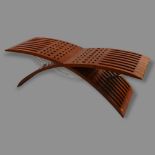 Tressera, a Gavina sculptural bench in iroko and polished stainless steel, designed by Jaime