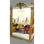 A 19th century gilt composition framed pier glass mirror, with mask decorated pediment and fluted