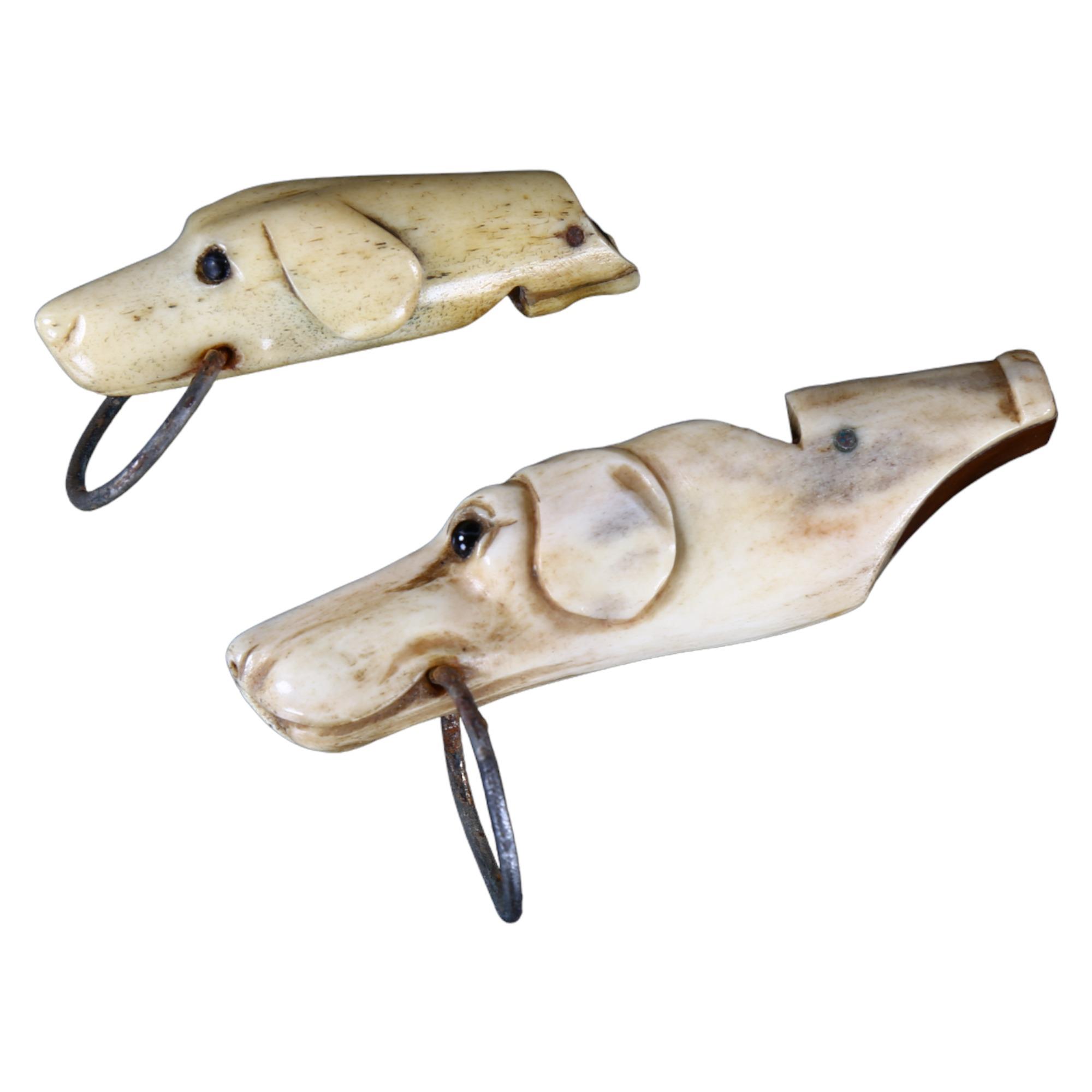 2 x 19th century carved bone dog's head design whistles with glass eyes, largest length 6.5cm