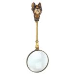 A brass magnifying glass, with carved and painted wood handle in the form of a French Terrier,