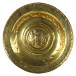 An 18th century brass harvest bowl, relief embossed central panel depicting men carrying a