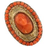 An Antique coral cameo ring, unmarked yellow metal settings with relief carved panel depicting