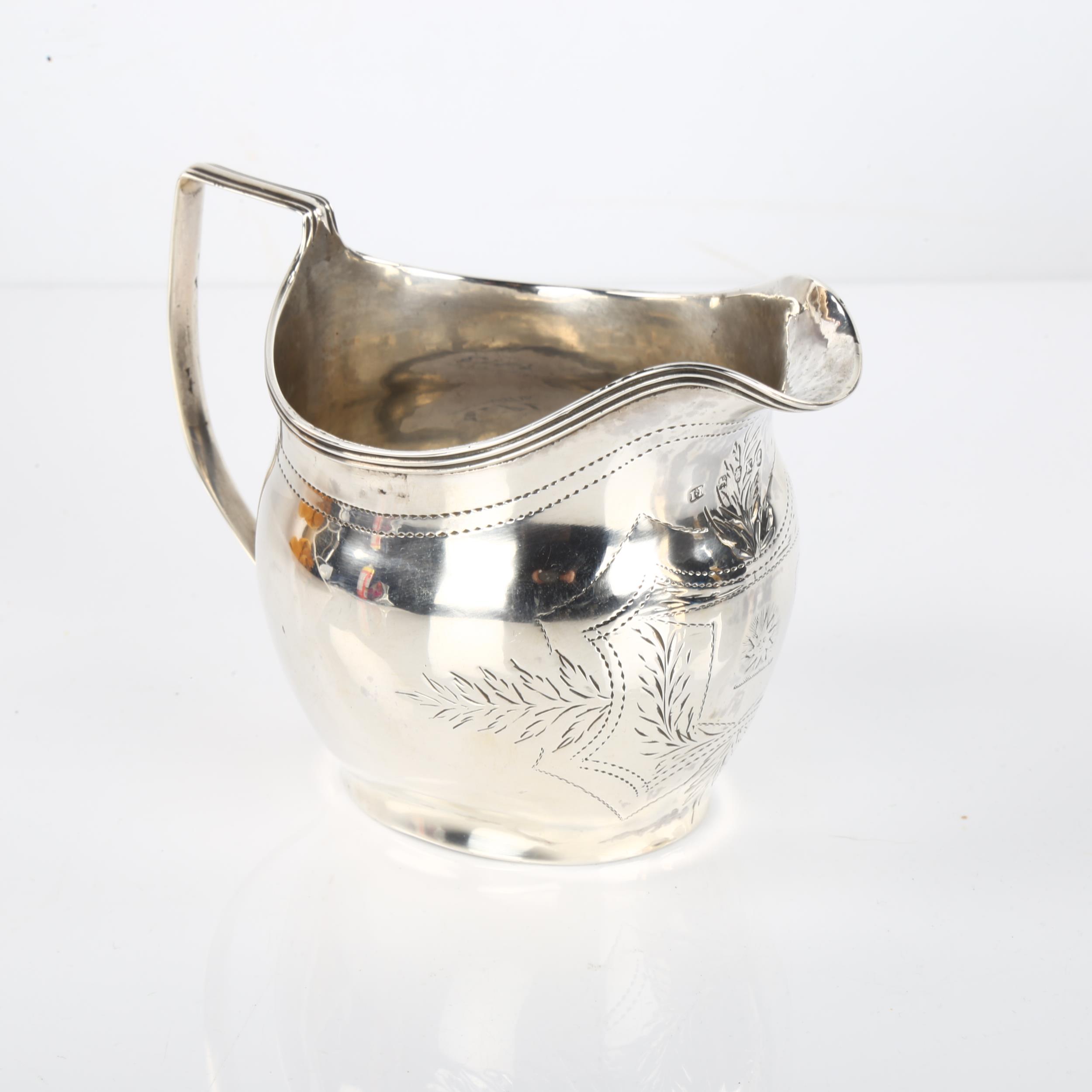 A George III silver helmet cream jug, with bright-cut engraved decoration and reeded rim, probably - Image 2 of 3