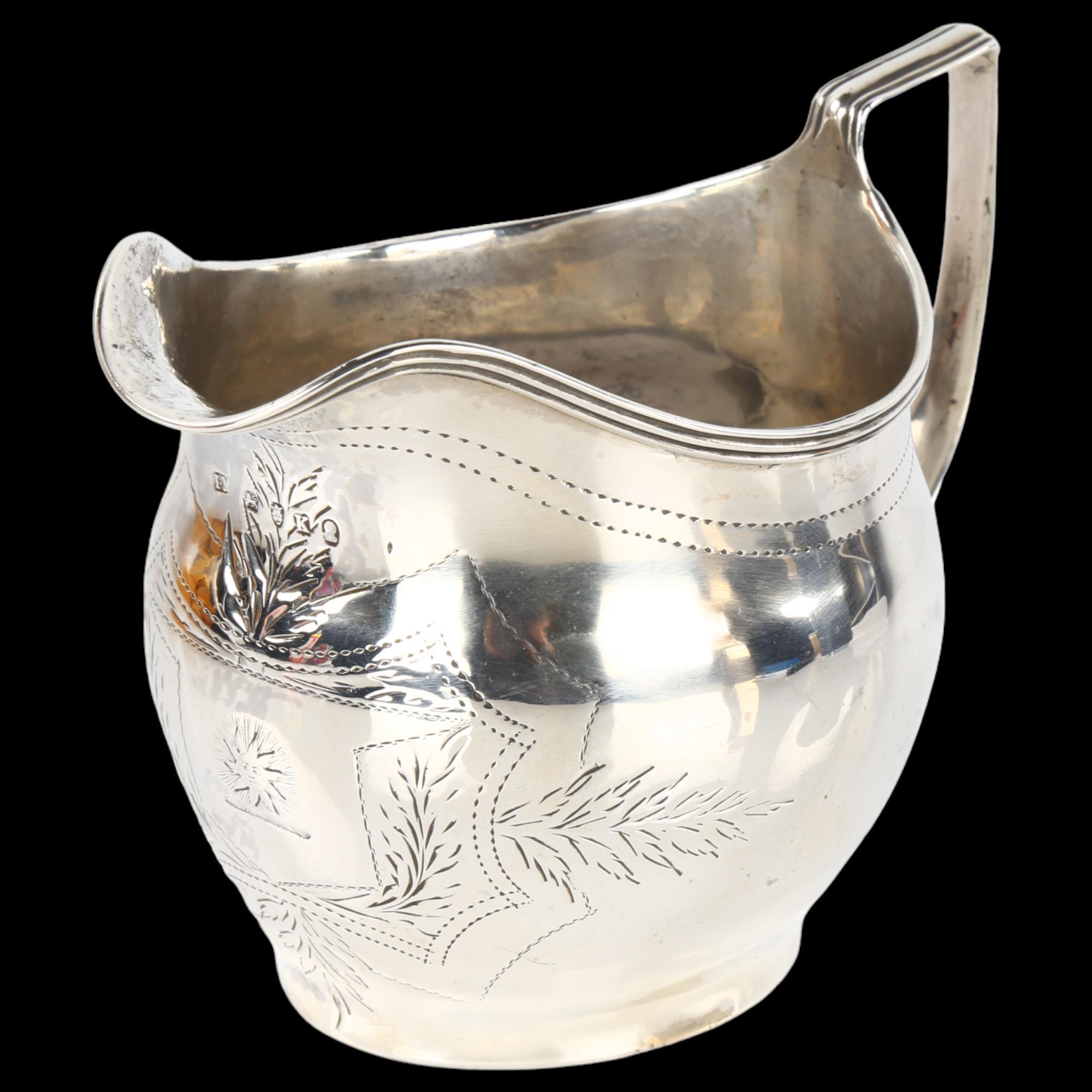 A George III silver helmet cream jug, with bright-cut engraved decoration and reeded rim, probably