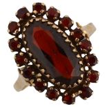 A 9ct gold garnet cluster ring set with oval and round-cut garnets, setting height 21.2mm, size P,