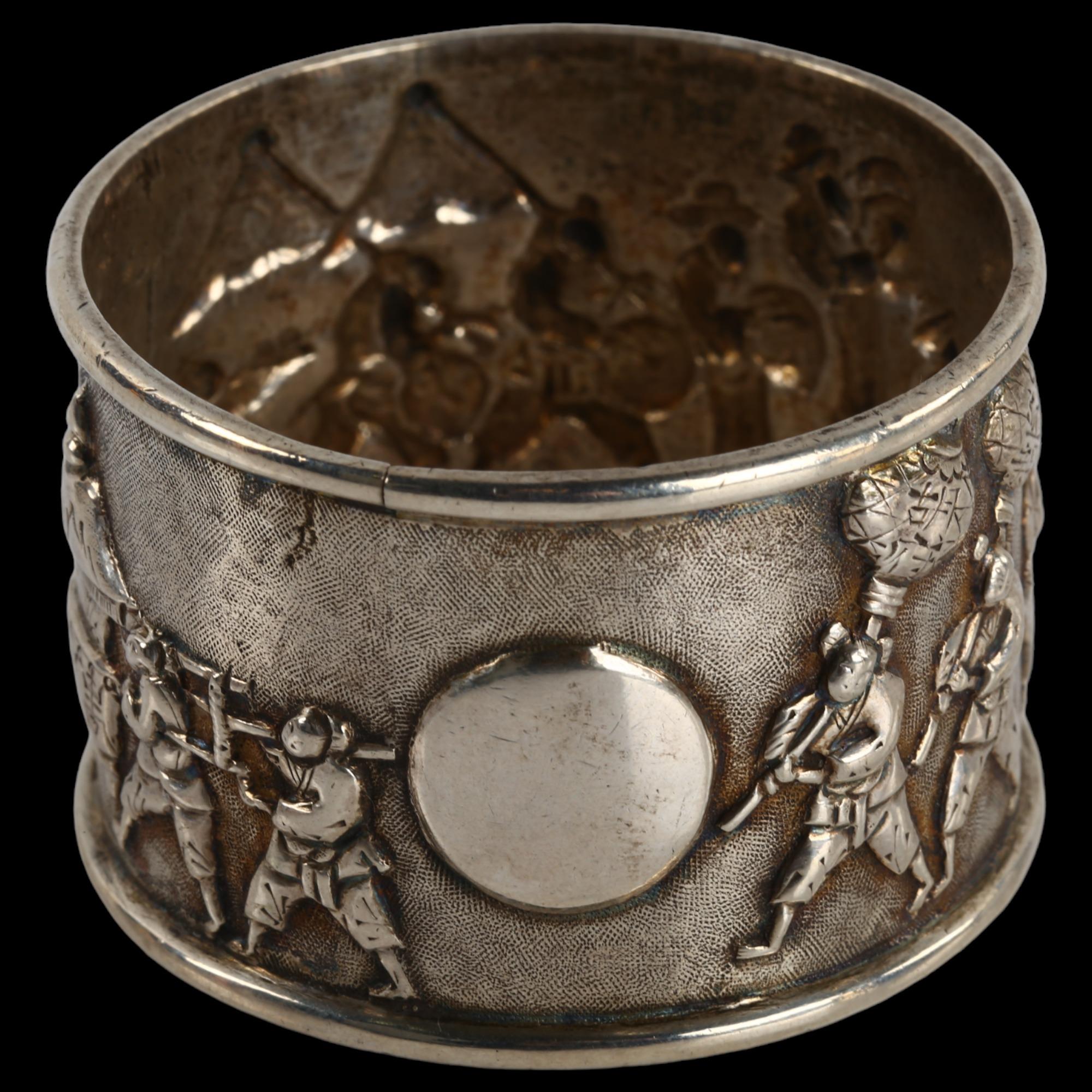 A Chinese export silver napkin ring, musical procession decoration, by Tuck Chang, circa 1900,