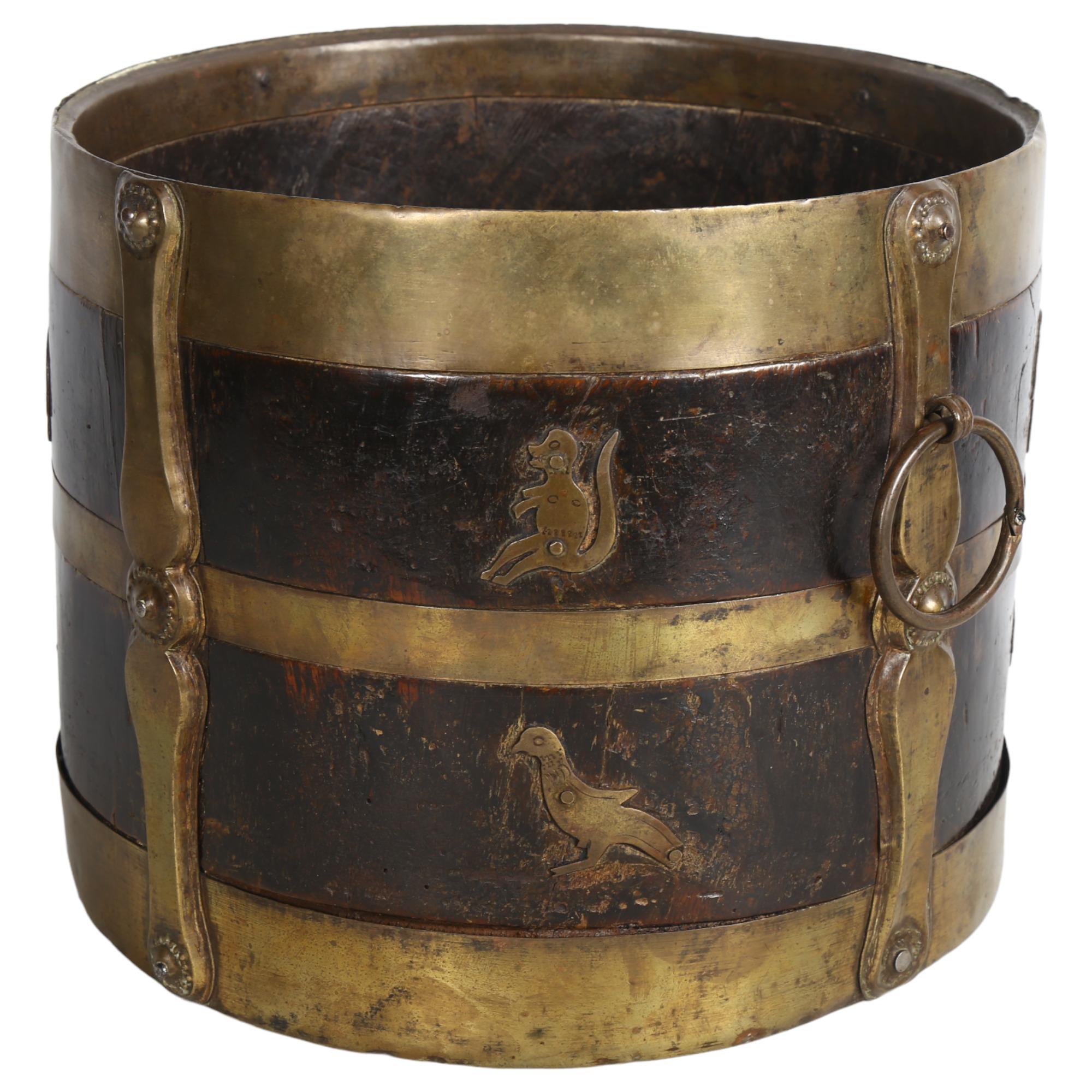 A 19th century Indian wood and brass-bound bucket with ring handles, stylised strapwork and animal