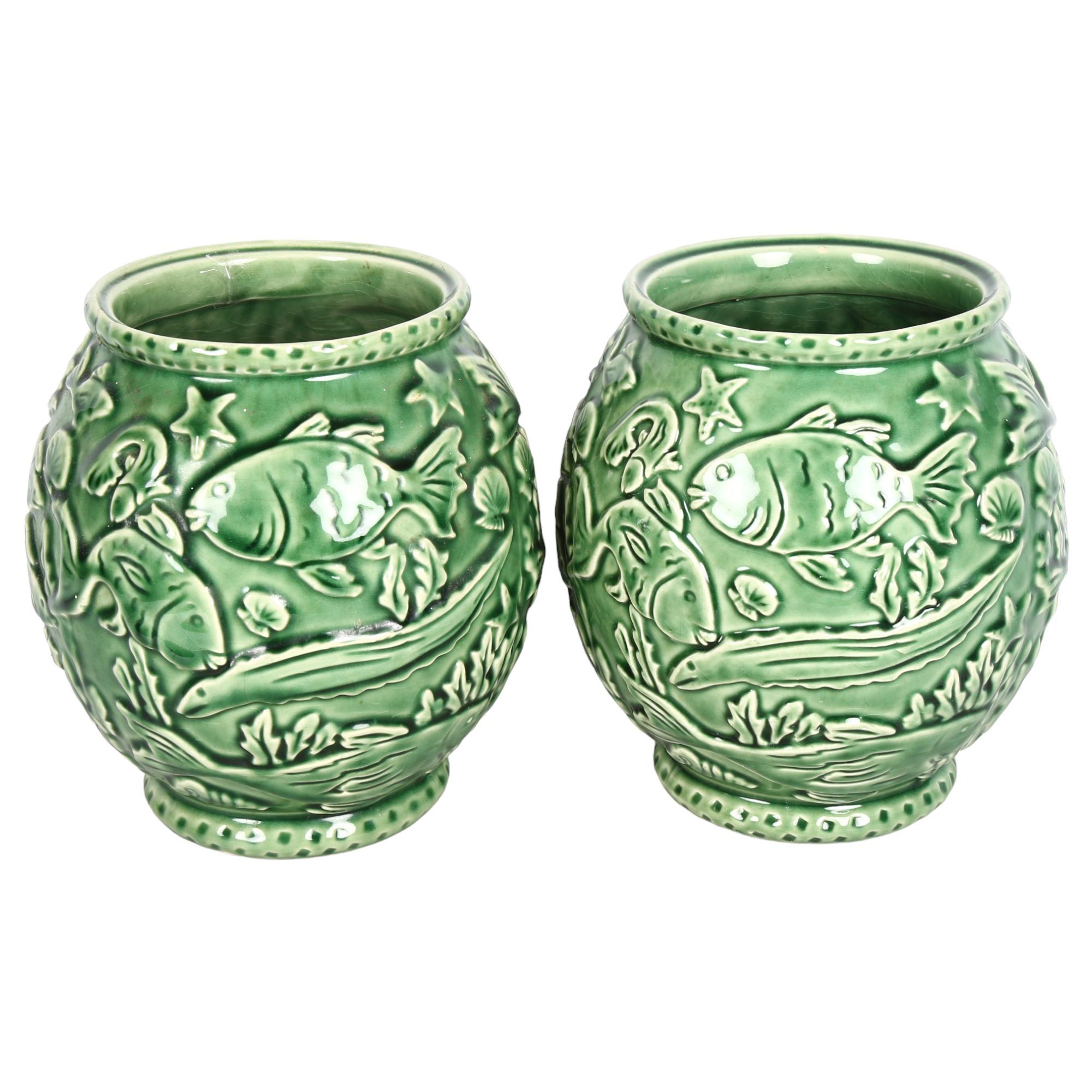 A pair of French green glaze pottery vases, with relief moulded under-sea decoration, height 21cm