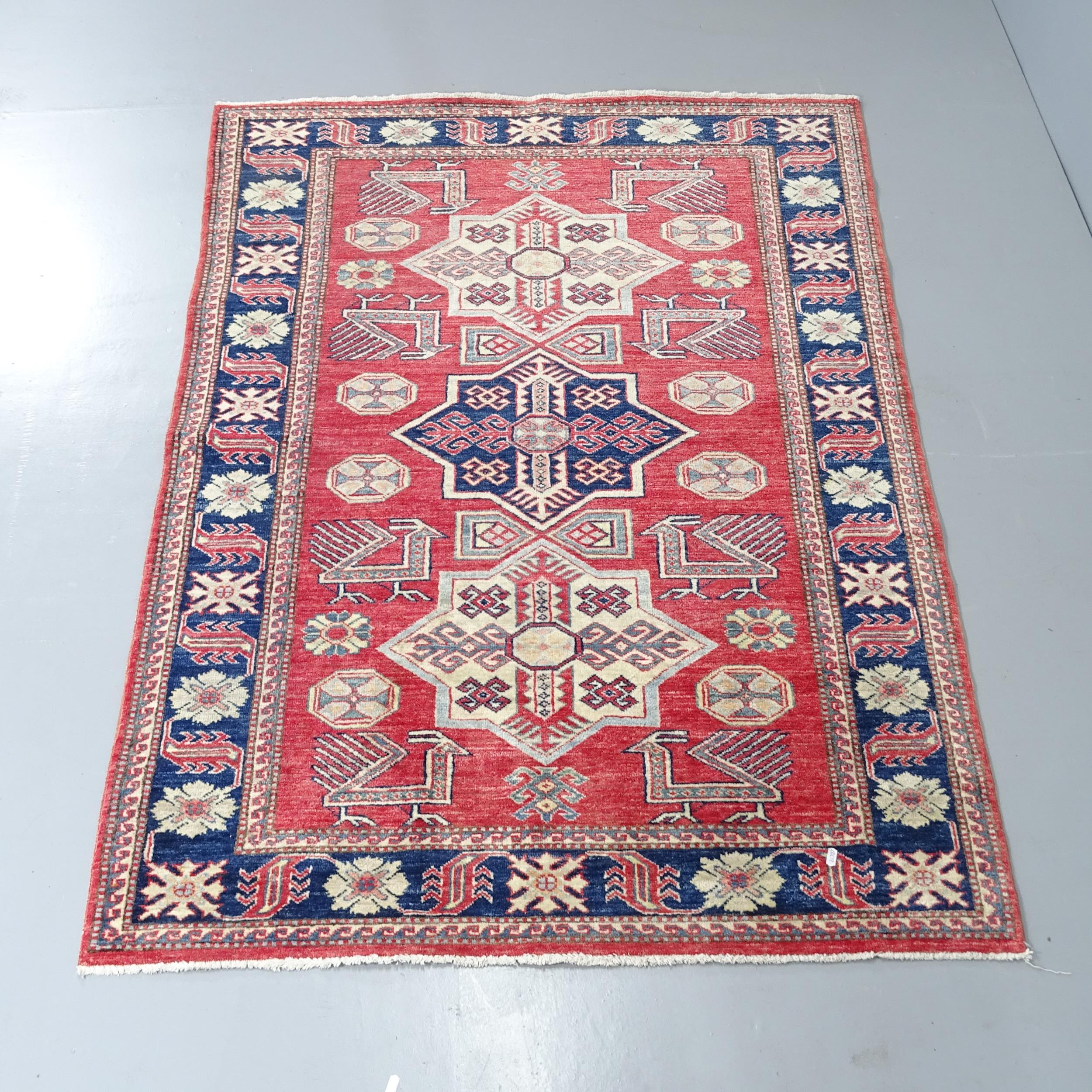 A red-ground Kazak rug. 172x121cm. Good overall condition.