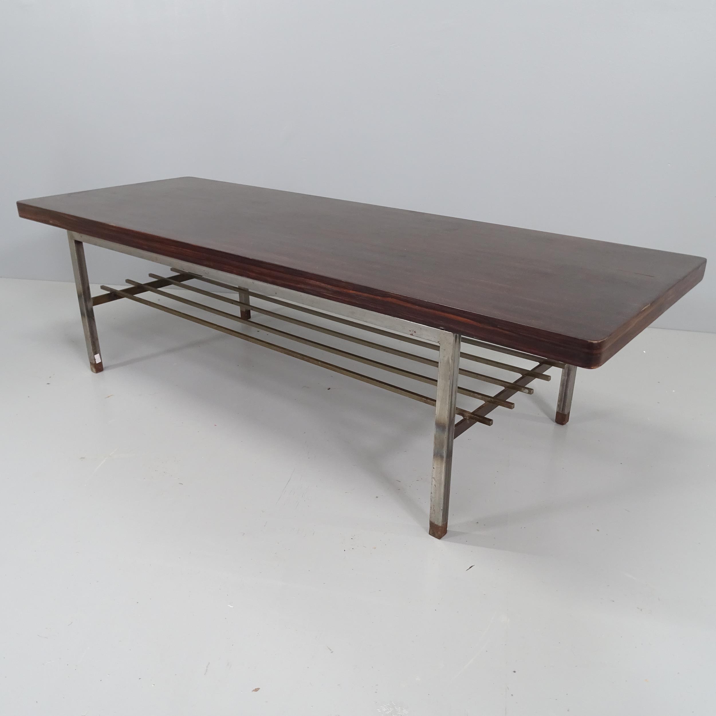 A mid-century coffee table, the stained walnut veneer top on steel base. 140x39x51cm