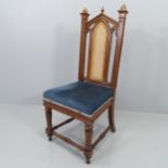 An antique Gothic oak and upholstered Pugin style chair, with cane panelled back.(Originally from