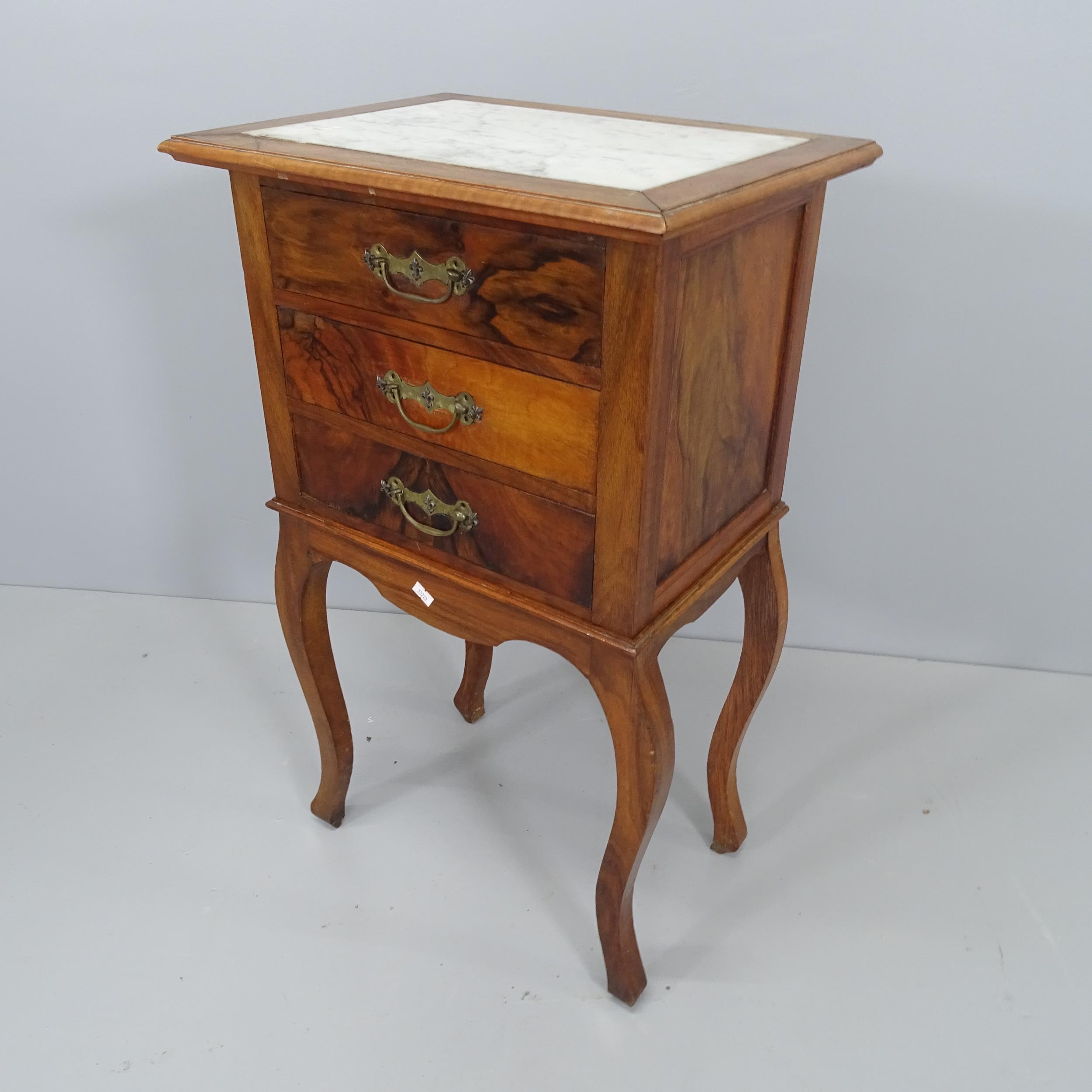 A French burr walnut three-drawer bedside table with inset marble top, raised on cabriole legs.