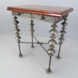 An unusual design side or lamp table, with the mahogany top on ornate base with beaten metal