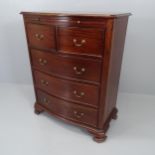 A reproduction mahogany bow front chest of two short and three long drawers, with brushing slide and