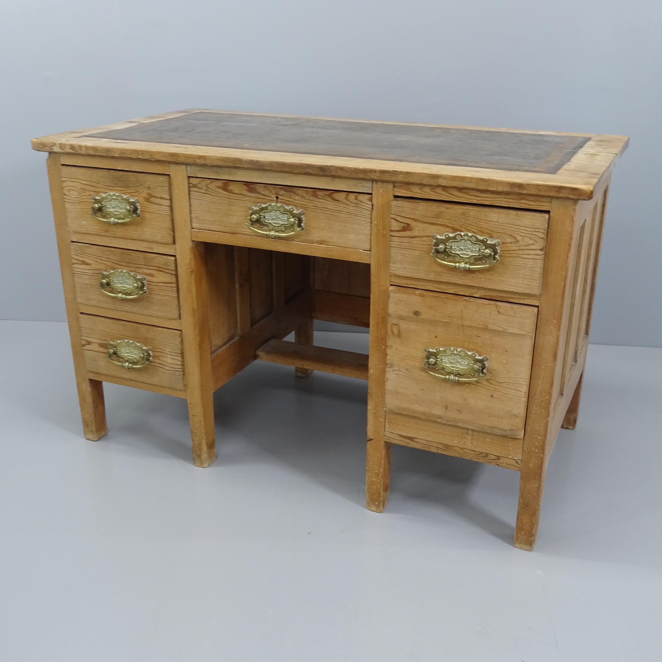 A Vintage pine knee hole writing desk, with six drawers and inset tooled and embossed leather