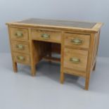 A Vintage pine knee hole writing desk, with six drawers and inset tooled and embossed leather