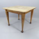 An antique oak American primitive rectangular kitchen table, raised on square tapered legs with ball