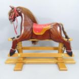 A modern mahogany rocking horse on pine stand, signed John H. Turner, 1999. Overall 108cmx84x41cm