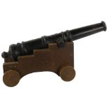 A cast-iron garden cannon on oak trolley, cannon length 52cm Cannon in good condition, some pitting