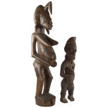 Two African carved wood figures, small figure has rope and shell detail, tallest 74cm Natural splits