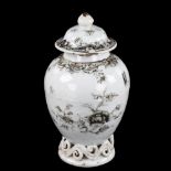 An Antique Chinese porcelain tea jar, with scrollwork base and black and gilded decoration, height