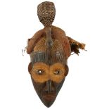 An African carved wood tribal mask with basket weave rattle headdress, height 42cm Good complete