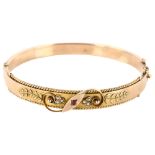 An Edwardian 9ct rose gold ruby and pearl hinged bangle, with floral motif and rope twist border,