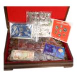 A boxful of world coins, including commemorative items and various banknotes