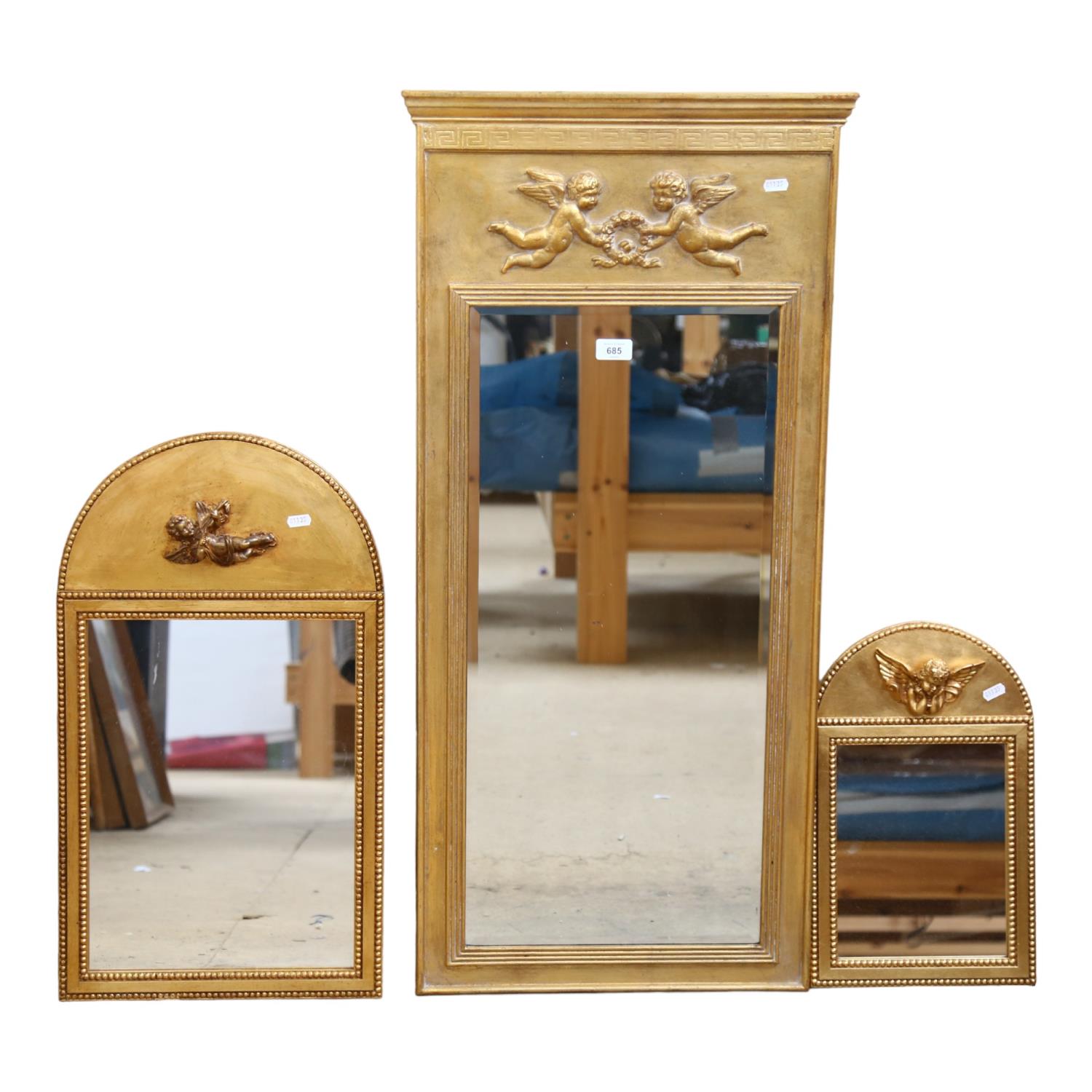 A gilt-framed bevel-edge wall mirror, with design of cherubs, H1m, and 2 arch-top similar smaller