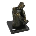 A bronzed ceramic sculpture of a nude seated figure, on painted wood plinth, H23cm