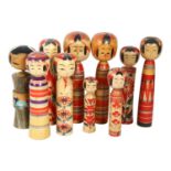 10 Oriental carved and painted wood Kokeshi dolls, tallest 21.5cm