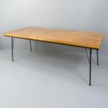 A mid-century teak dining table with ebonised frieze and iron rod legs. 198x71x84cm