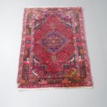 A red-ground Baluchi rug. 155x107cm One corner heavily stained. Others are faded. Generally worn.