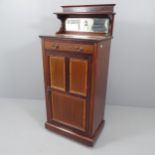 An Edwardian mahogany and satinwood strung music cabinet, with raised mirrored back and single