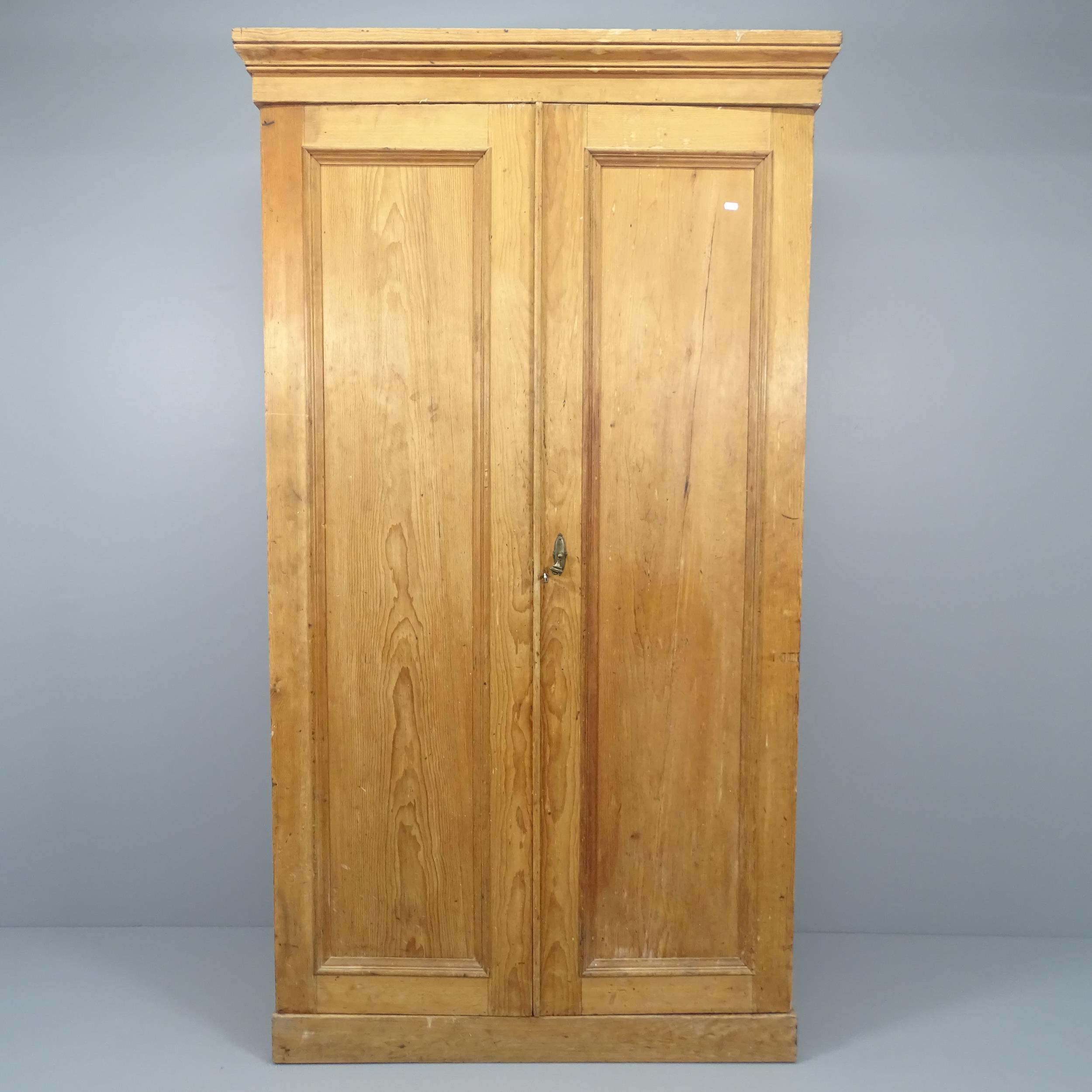 An antique pine two-door compactum wardrobe, with fitted interior. 116x206x57cm.