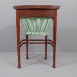 An Edwardian Arts & Crafts work table in the manner of Liberty, the top opening to reveal a fitted