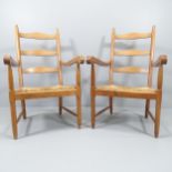A pair of mid-century ladderback lounge chairs, in oak with rush seats.